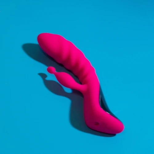 На фото зображений яскраво-рожевий вібратор-кролик з виразним ребристим рельєфом.
