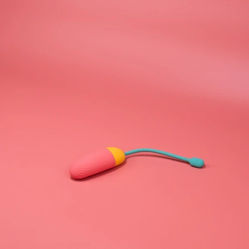 На фото изображено розово-желто-мятное виброяйцо Magic Motion Vini Lite для женщин на розовом фоне.