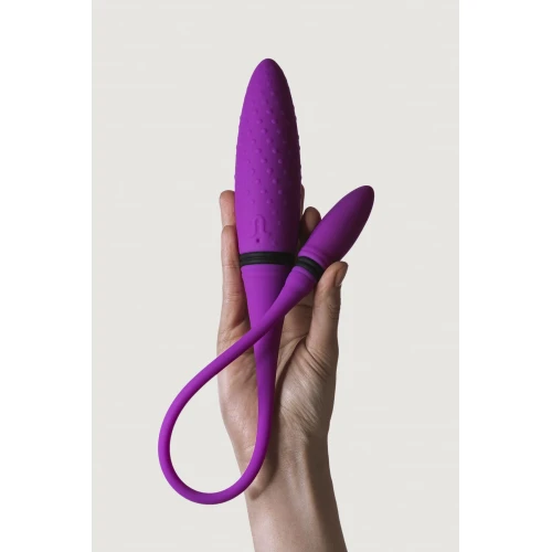 На фото изображен фиолетовый двойной вибратор Adrien Lastic AD-2 для пар на белом фоне.
