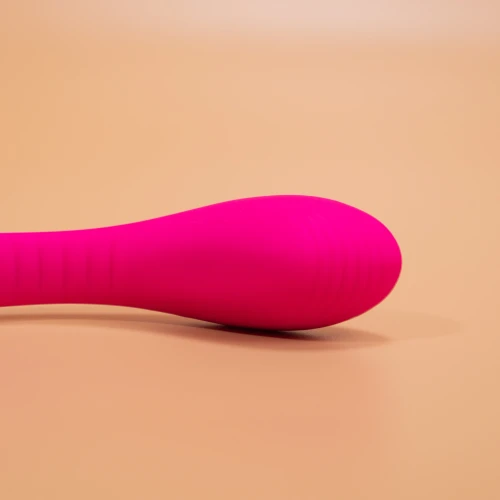 На фото изображен розовый двойной вибратор с функцией "Смарт" Lovense Dolce (Quake) для женщин на бежевом фоне.