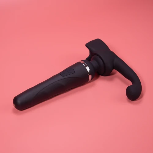 На фото изображена черная насадка Lovense Domi Male Attachment для вибраторов Domi и Domi 2 для мужчин на розовом фоне.