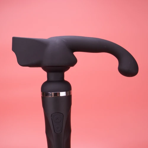 На фото изображена черная насадка Lovense Domi Male Attachment для вибраторов Domi и Domi 2 для мужчин на розовом фоне.