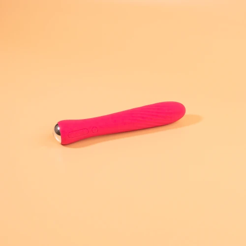 изображён компактный розовий вибратор с жёлтым основанием и рельефной поверхностью.