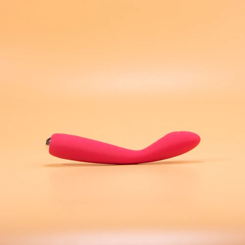 на фото зображений рожевий вібратор який лежить горизонтально та має срібні вставки 