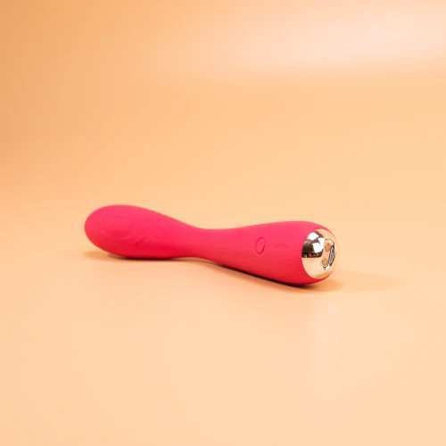 На фотографії зображено рожевий вібратор із чітко помітними срібними вставками.