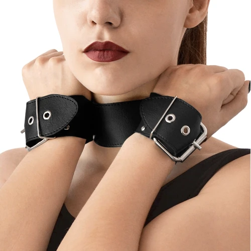 На фото зображено чорний нашийник з натуральною шкірою Art of Sex Bondage Collar with Handcuffs унісекс на білому тлі
