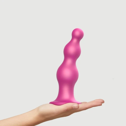 На фото зображено рожеву насадку для страпону Strap-On-Me Dildo Plug Beads Framboise Metallic XL для пар на світлому тлі