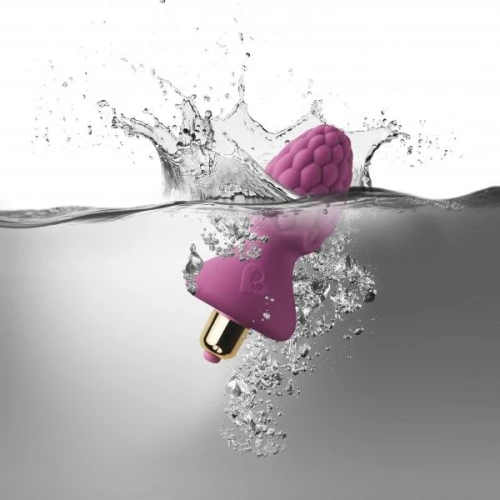 На фото зображено фіолетовий анальний стимулятор у формі малини Rocks Off Ass-Berries 7 Raspberry унісекс на світлому фоні