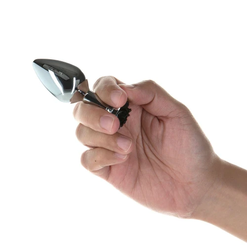 На фото изображена анальная пробка с черным цветком Rose Anal Plug – Black унисекс на светлом фоне