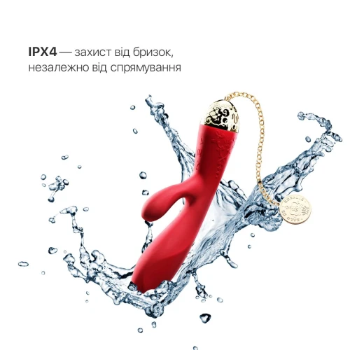 На фото изображен красный вибратор-кролик с золотой цепочкой Zalo - Rosalie Bright Red для женщин на белом фоне.