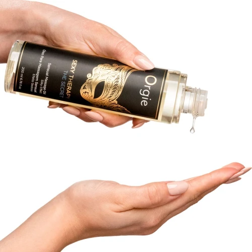 На фото изображено черное гибридное массажное масло Orgie – Sexy Therapy The Secret (200 мл) для пар на светлом фоне.