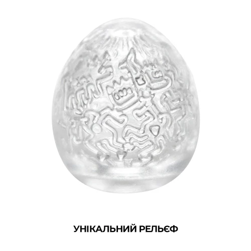 На этом фото изображено белое яйцо-мастурбатор Tenga Haring EGG Party для мужчин на светлом фоне