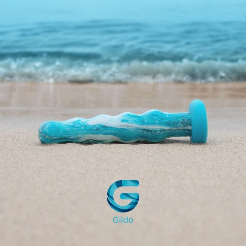 На фото зображено скляне дилдо морського кольору Gildo Ocean Flow Glass Dildo унісекс на тлі пляжу.