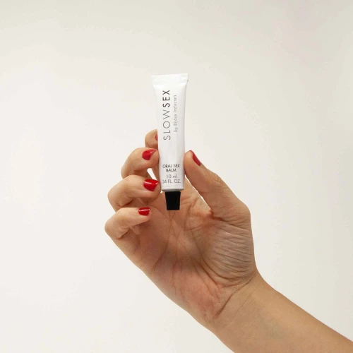 На фото зображено білий бальзам для мінету Bijoux Indiscrets SLOW SEX - Oral sex balm з кокосовим смаком та ароматом унісекс на білому тлі.