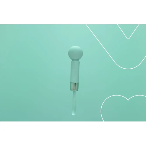 На фото зображено зелений магічний вібромасажер FairyGasm Pearlstasy green для жінок на зеленому тлі.