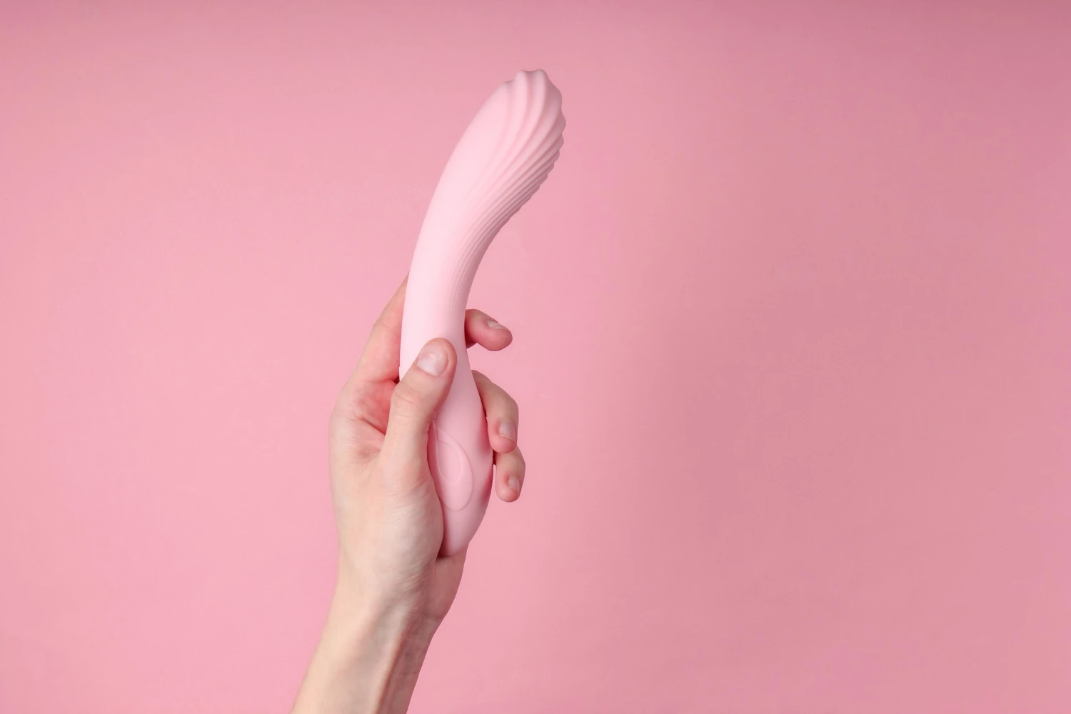 на рожевому фоні зображений рожевий вібратор для сосків та клітора
