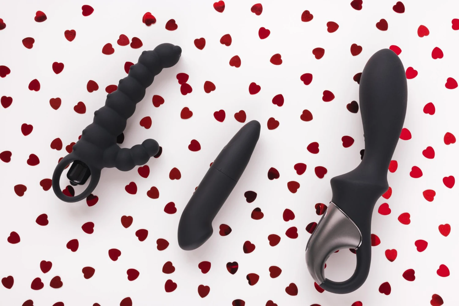 на фото зображені унісекс вібратори різних моделей на білому фоні з сердечками