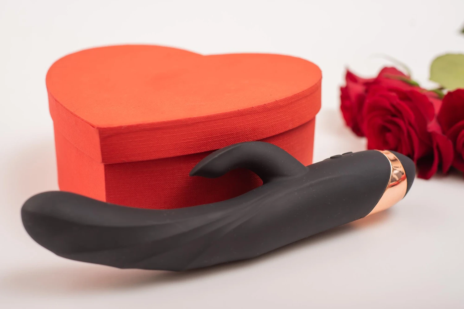 на фото изображен анальный вибратор, подарочная упаковка и красные розы