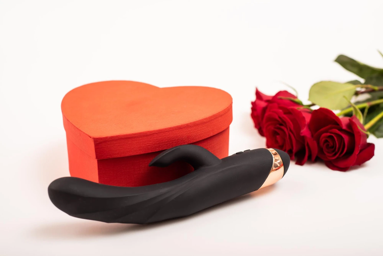 на фото зображений чорний анальний вібратор, подарункова коробка та червоні рози