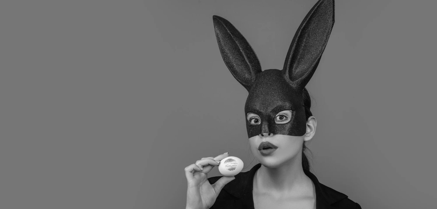 чорно-біла фотографія дівчини в чорній масці зайчика для БДСМ ігор