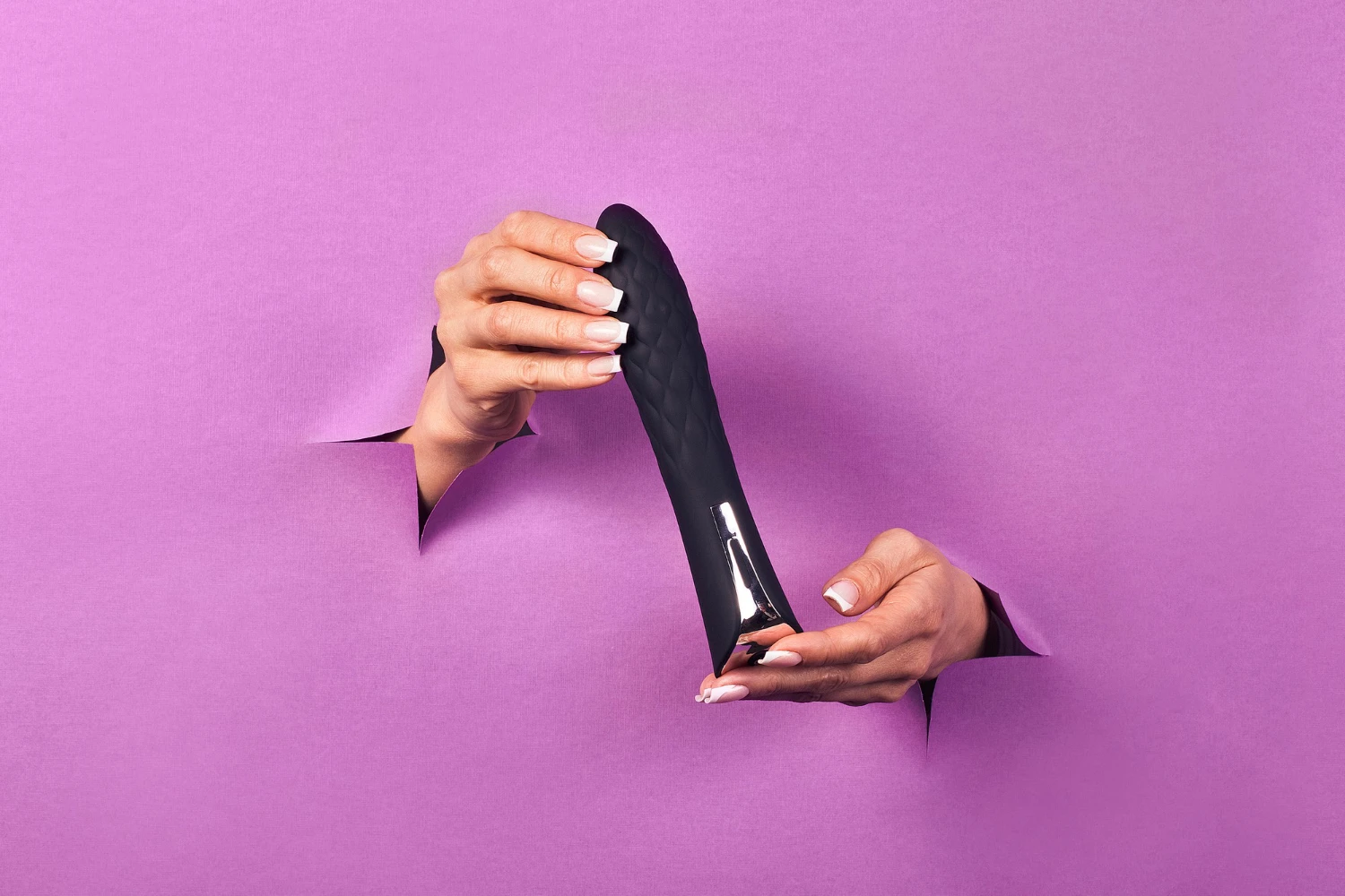 изображен большой черный дилдо в женский руках на сиреневом бумажном фоне