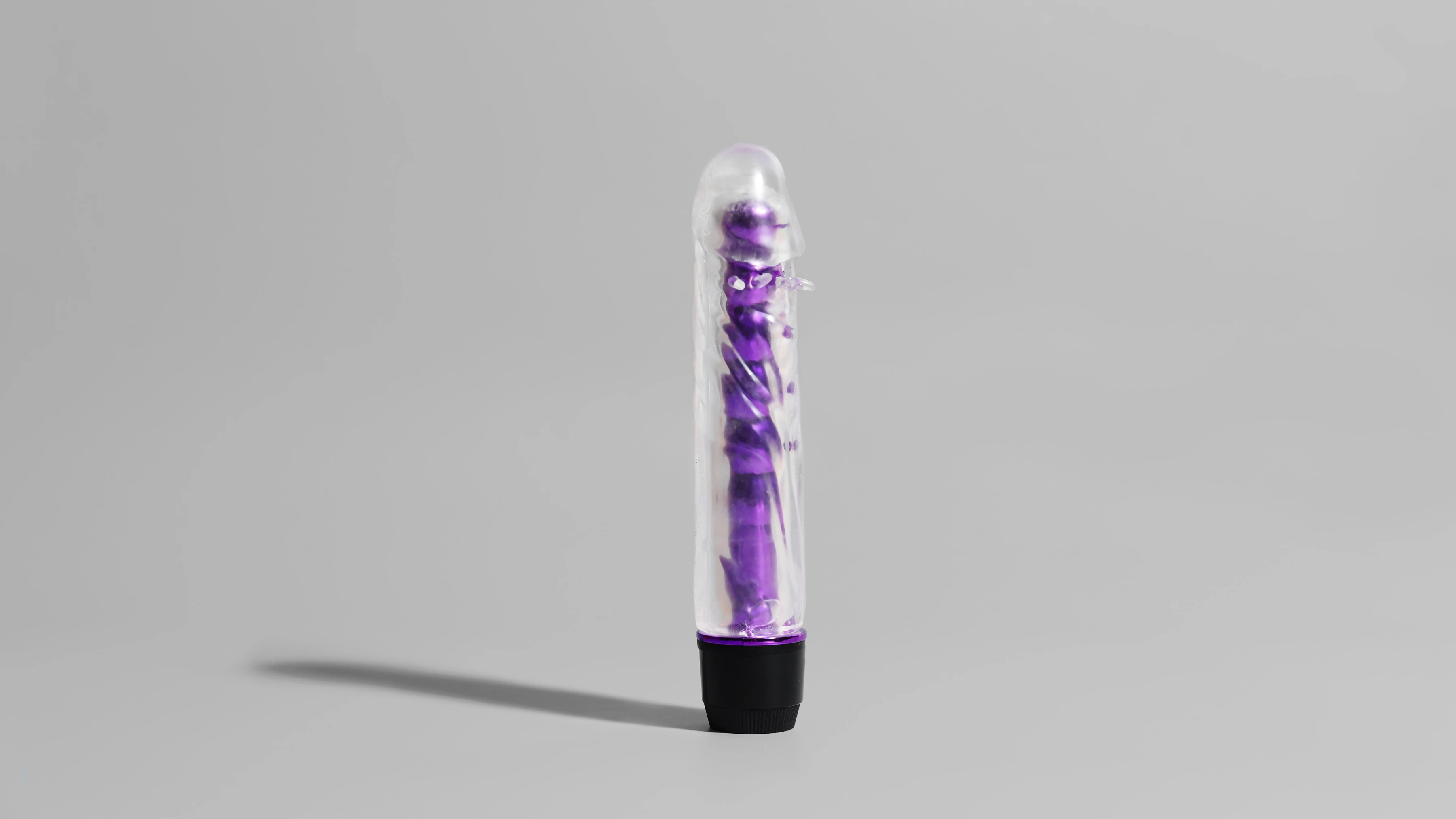 на сером фоне изображен реалистичный вибратор для девушек