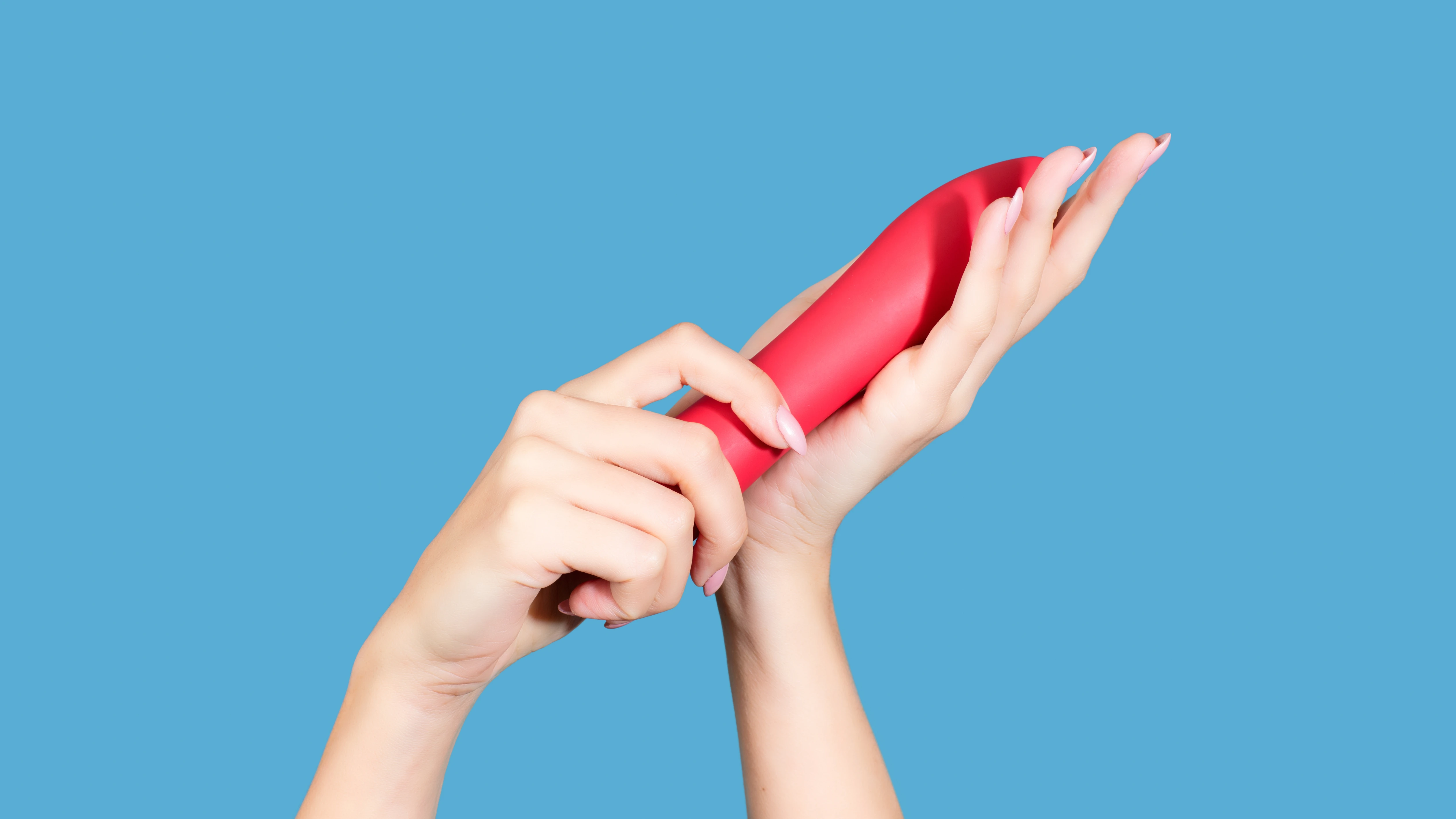 на блакитному фоні зображена жіноча рука з червоним страпоном у руках