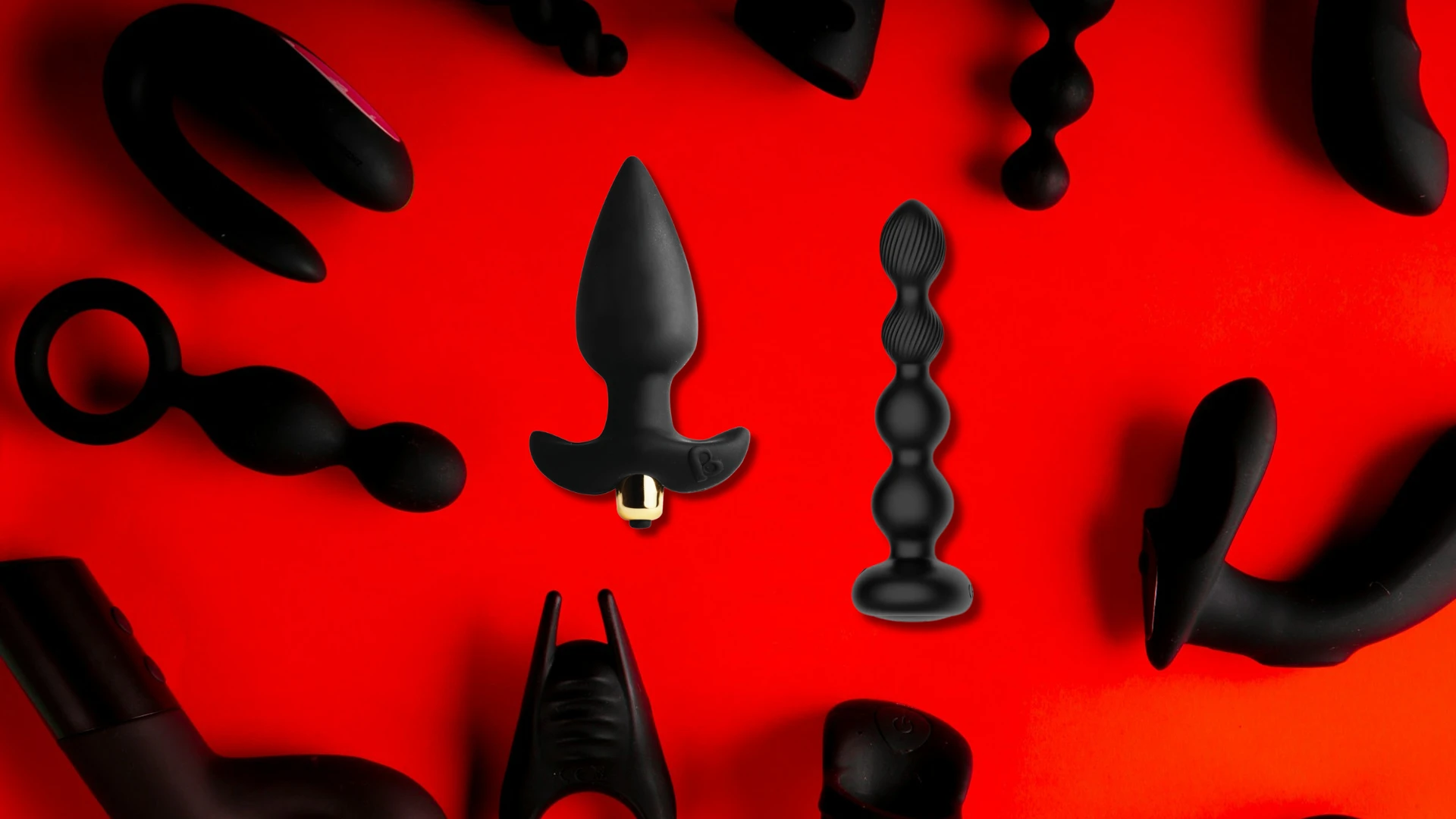 на червоному фоні зображені різні види чорних анальних вібропробок