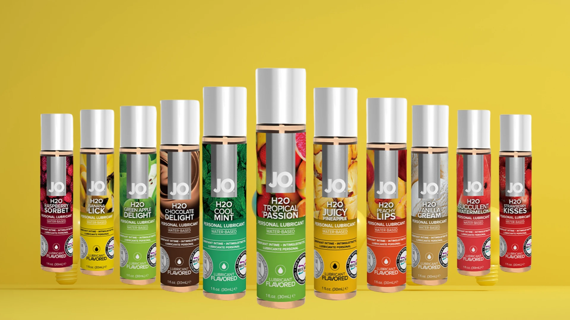 на фото зображені всі види оральних лубрикантів JO на жовтому фоні