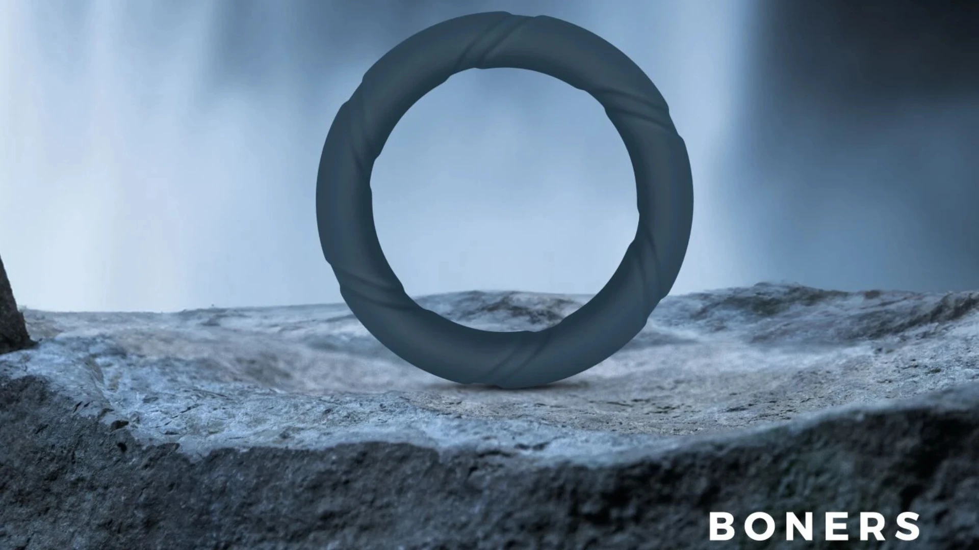 на фото изображено эрекционное кольцо на член марки Boners на синем фоне природы