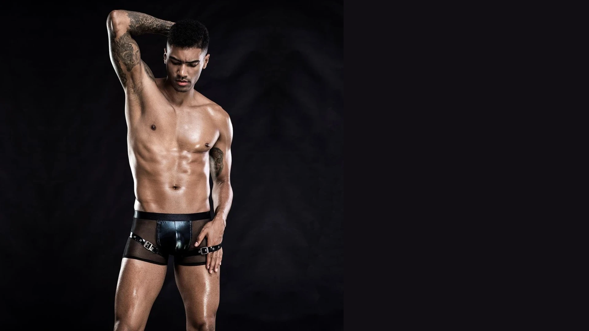 изображен сексуальный мужчина со споортивной фигурой в эротических трусах на черном фоне