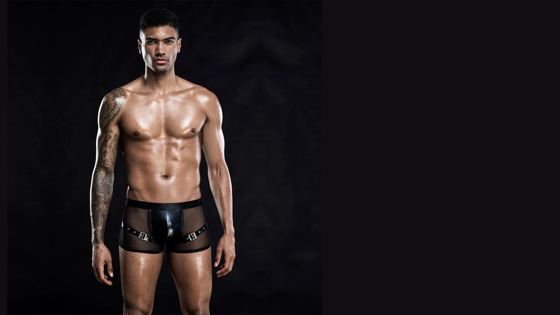 зображений привабливий чоловік в еротичних трусах для сексу на чорному фоні