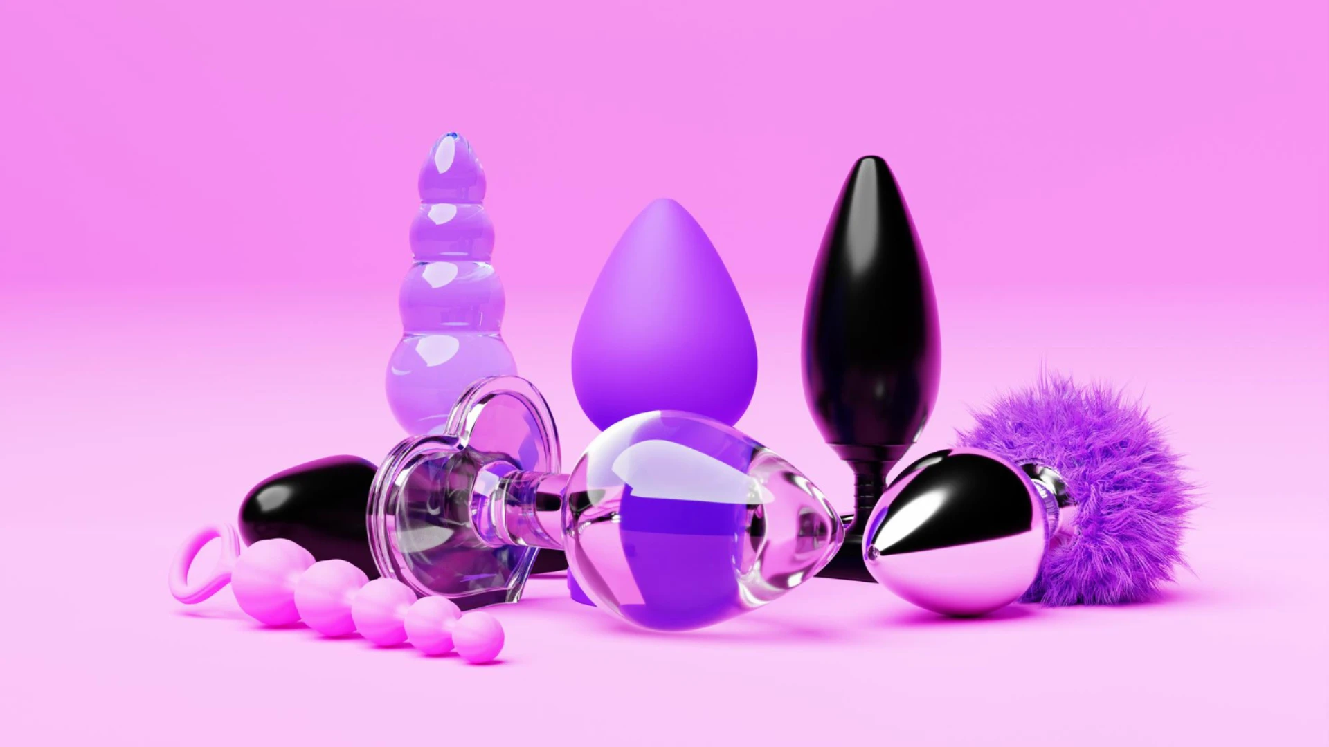на розовом фоне изображены разные виды анальных пробок из разных материалов разных цветов