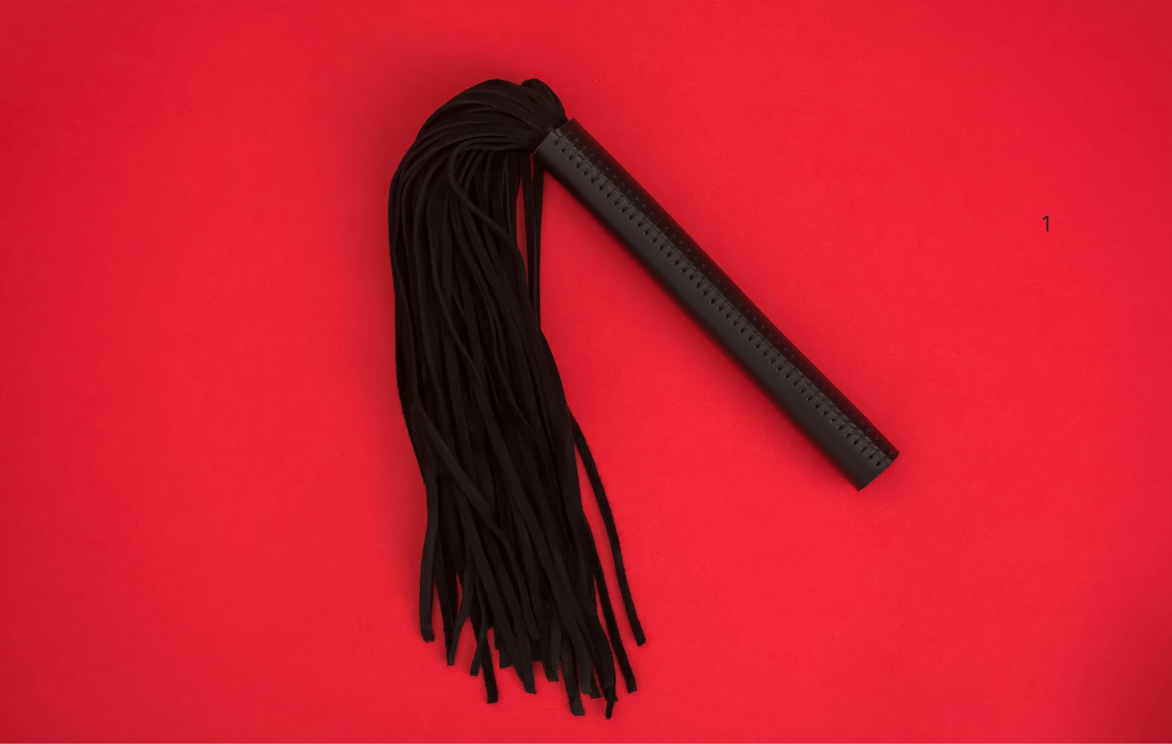 на красном фоне изображена черная плетка для БДСМ секса из сексшоп