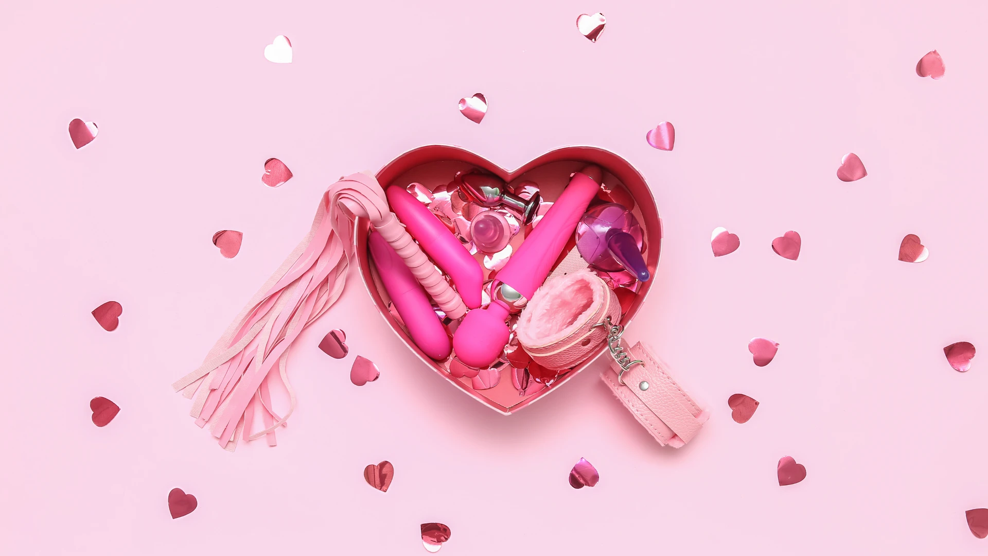 подарунки сексшоп в рожевій коробці у вигляді сердця на рожевому фоні
