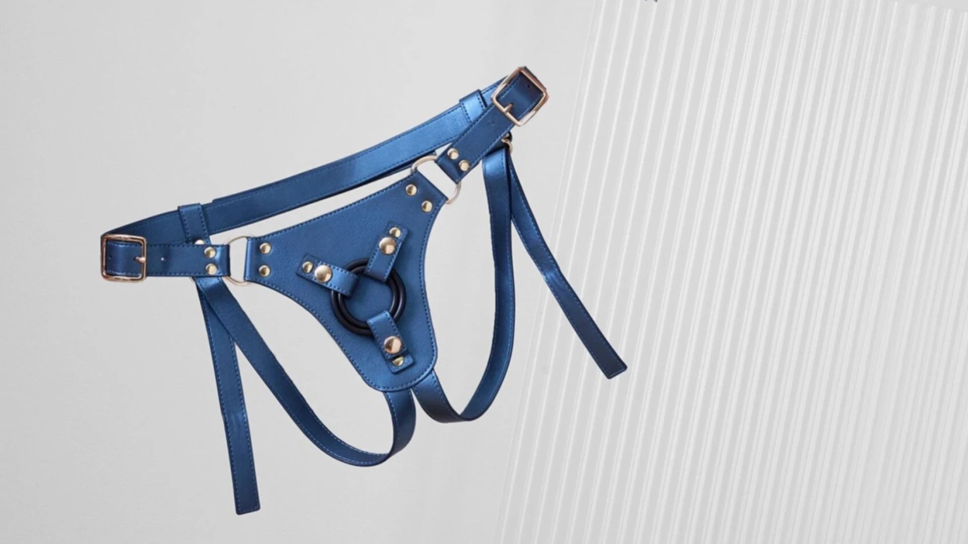 на сірому фоні пояс для страпона шкіряний темно блакитного кольору