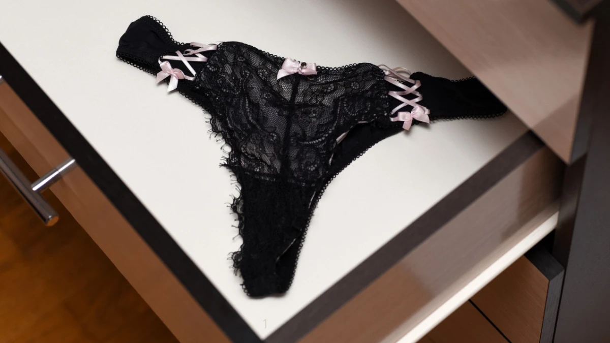 чорні еротичні стрінги жіночі з рожевими вставками в шкафу комоду
