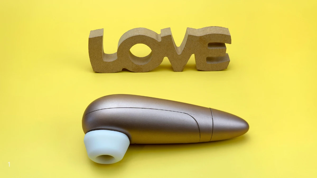 вакуумний вібратор для жінок на жовтому фоні та надпис Love