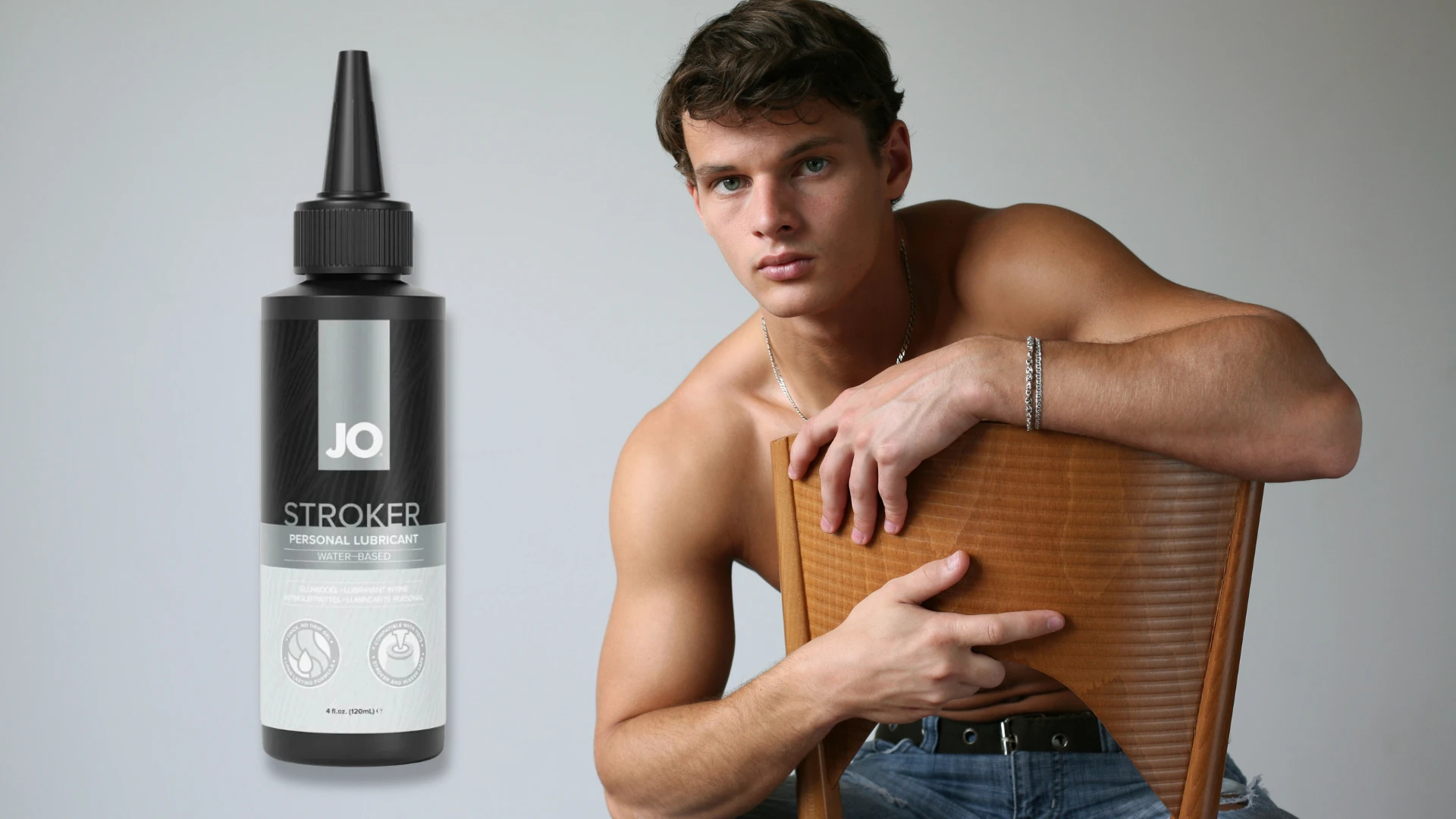на фото зображений лубрикант для мастурбаціі JO Stroker та привабливий чоловік на задньому плані