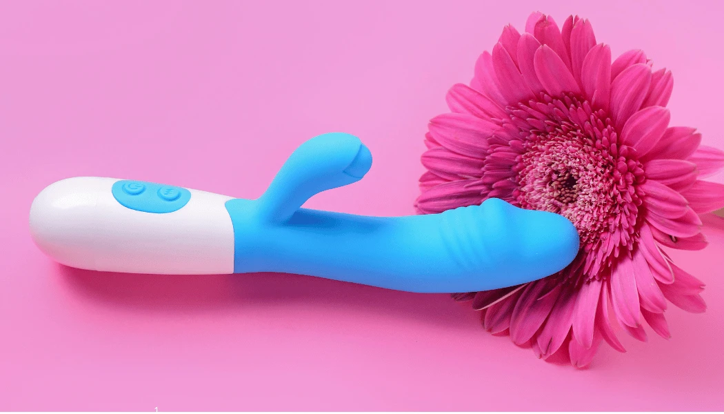 на фото зображений голубий вібратор кролік та ярко рожева квітка
